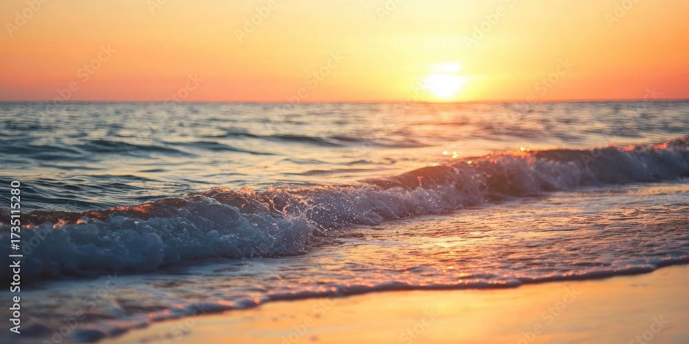 Fototapeta premium A serene beach scene with a vibrant sunset, calm waves, and a golden sand beach under a clear sky.
