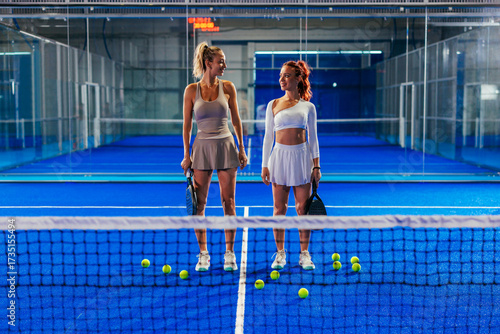 Two young women standing ready for a doubles match in padel tennis
