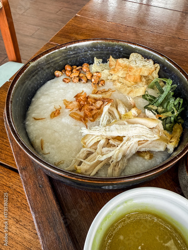 Wallpaper Mural Traditional Indonesian chicken porridge or Bubur Ayam served with crackers, chili sauce, green sauce, and toppings on a wooden tray over rustic wooden table. Torontodigital.ca