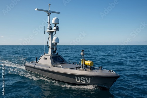 An unmanned surface vessel navigates the open sea under a clear sky. This USV is equipped with advanced sensors for autonomous operations.