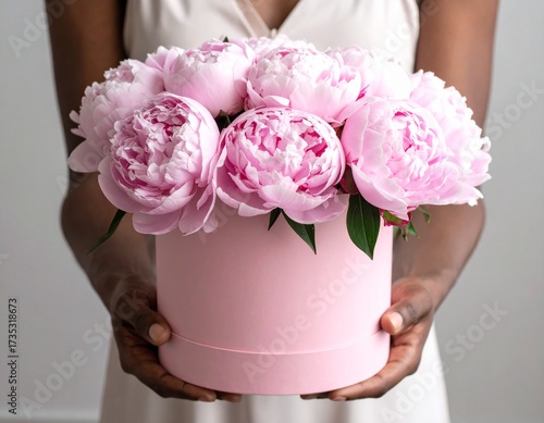 Elegant pink peonies elegantly presented in a chic hat box, a perfect symbol of love and appreciation for any special occasion.