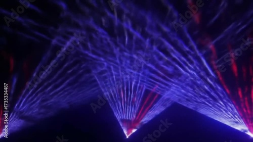 Colorful laser beams and light rays creating futuristic stage show atmosphere with blue and red reflections seemless looping animation 4k quality video 