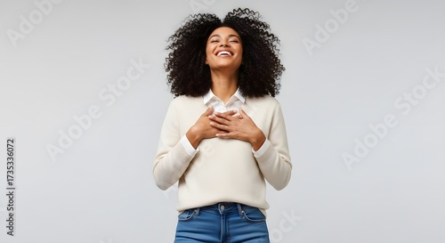 Gratitude and Serenity: A woman of color closes her eyes, hands over her heart, and is in a state of tranquil happiness and contentment. 