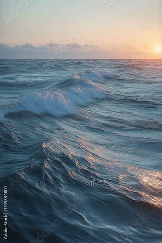 Calm ocean waves reflecting soft sunlight during a tranquil sunset with a clear sky and gentle clouds on the horizon