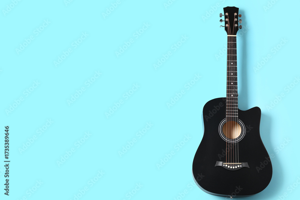 Fototapeta premium Modern black guitar on blue background