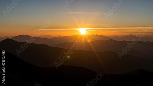 Majestic mountains bathed in golden light at sunrise, creating a serene vista