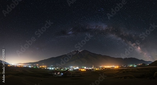 Panoramic night view of mountain and small town under starry sky landscape