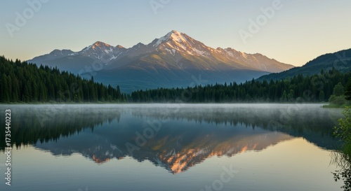 Scenic landscape photograph of a mountain range reflected in a tranquil lake under a clear sky