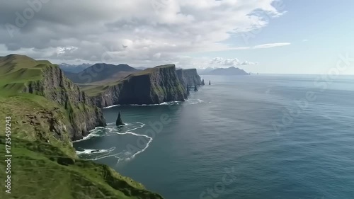 Coastal landscape with cliffs meeting the ocean under a cloudy sky aerial view