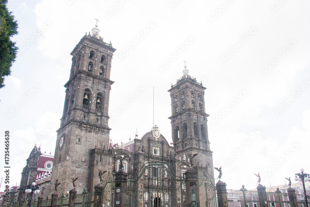 Fototapeta premium Full view of Puebla Cathedral showcasing its intricate Baroque architecture and detailed metalwork, captured from a clean perspective with no street distractions.