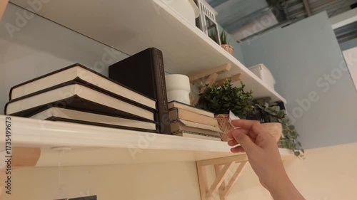 Hand Reaching for Book on Shelf in Home Interior