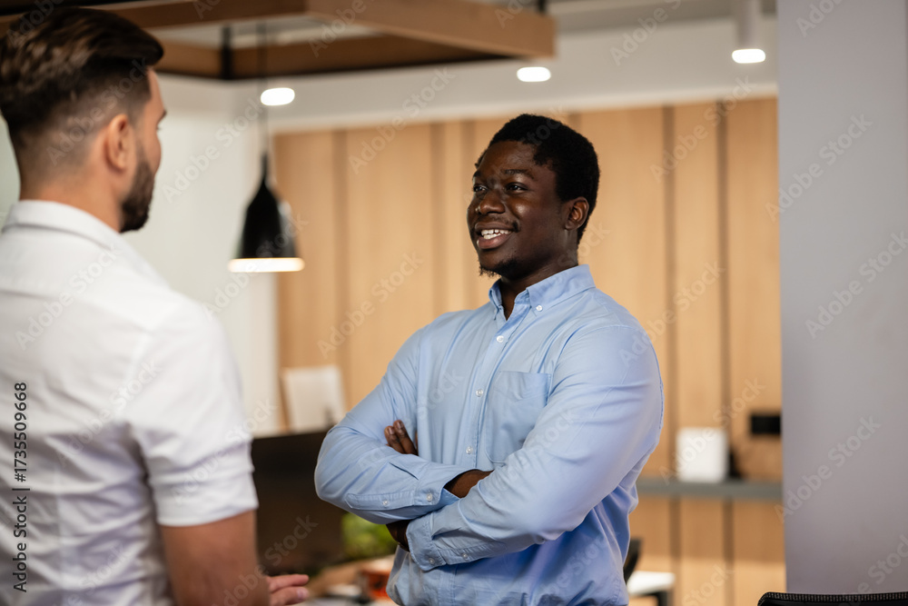 Obraz premium Two businessmen having casual discussion in modern office