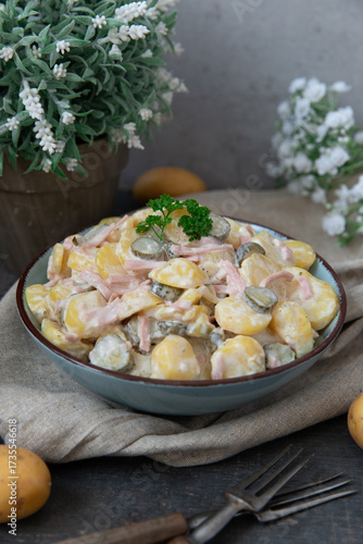 angerichteter Kartoffelsalat mit Wiener in einem kühlen Look auf einem Tisch aus Holz für die winterliche oder weihnachtliche Zeit