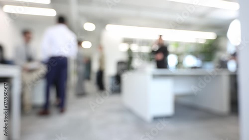 A blurry image of a group of people in a white office
