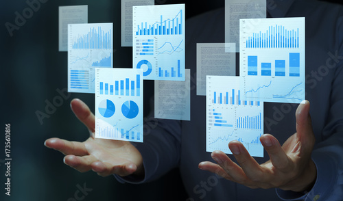 Business analysis reports with charts and graphs. Integrated content management platform. Digital document automation. Businessperson holding reports.