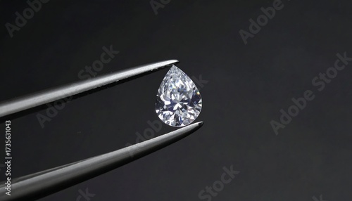 Pear-shaped diamond held by tweezers (1)