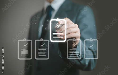 Businessman selecting digital checklist icon with check mark, symbol of workflow management, task approval, business compliance, project success, productivity, corporate governance, and efficiency.