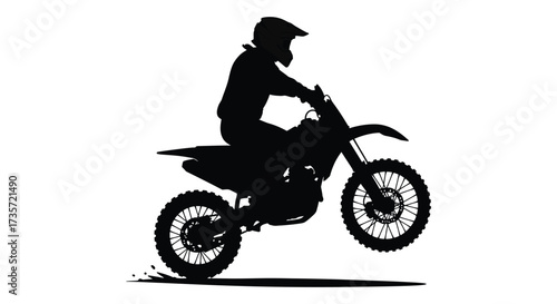 Silhouette of a motocross rider on a dirt bike in mid air
