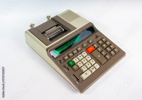 A vintage electronic printing calculator from the 1970s or 1980s, isolated on a white background. This retro office machine is a symbol of old technology from before the computer age.