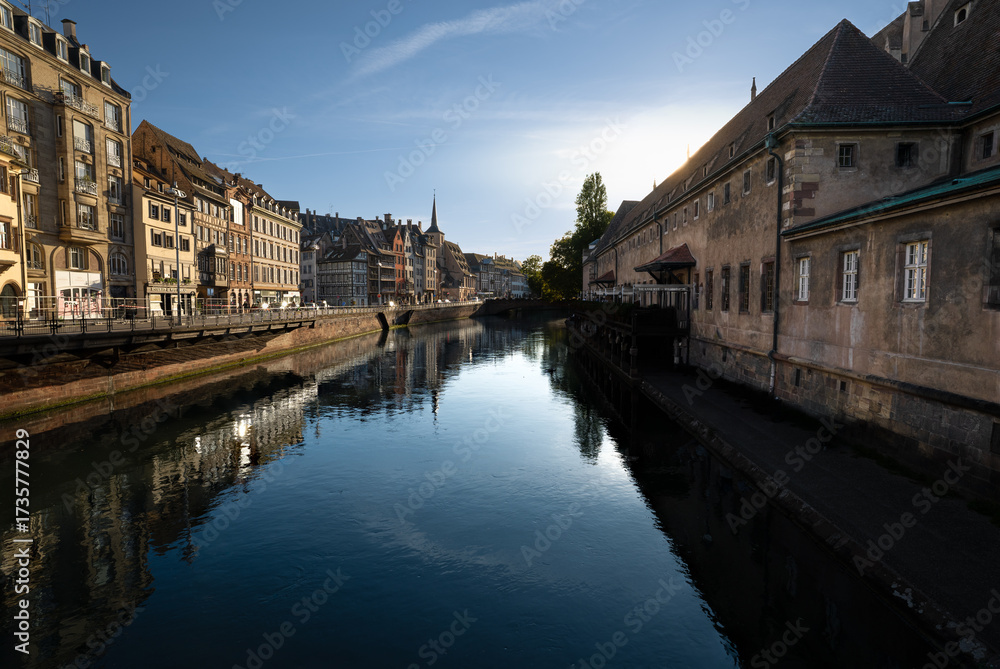 Fototapeta premium Landscape, river in the middle of a city and ancient city buildings at sunset
