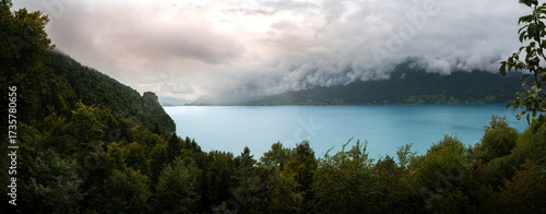 Billede på lærred View of water mountains inclement weather clouds and green