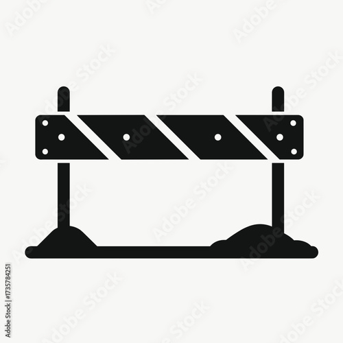 Isolated road barrier over a pile of dirt represents construction. Road barrier is symbolic of roadblocks and detours, emphasizing caution, and safety.