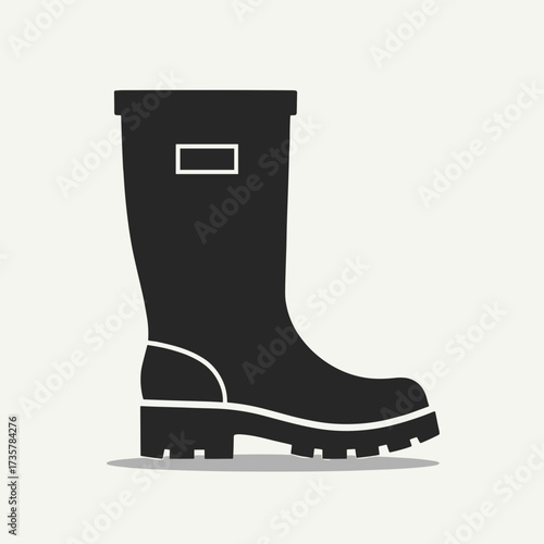 Black rubber boot isolated on white presents protective workwear. Rubber boot designed for safety and hygiene on building sites. Concept of rubber boot for promotional building works.