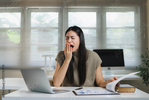 Tableau sur toile Young woman yawning, feeling fatigued at work