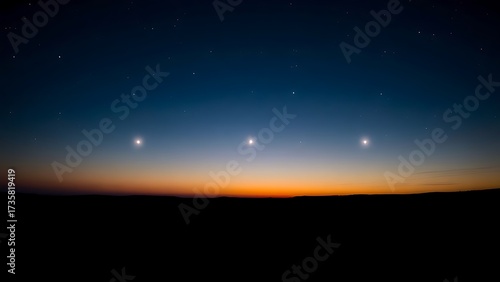 Six bright points of light aligned in the twilight sky above a dark, silhouetted horizon.