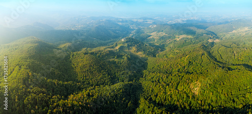 Photography Aerial view highlighting green forest mountains and valleys under a clear sky, s