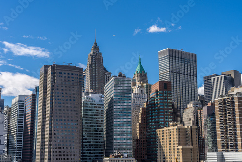 Lower Manhattan highrise buildings skyline view from Brooklyn bridge in a sunny day.
