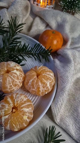 Cozy Christmas composition with tangerines on a plate and Christmas tree branches slow motion video