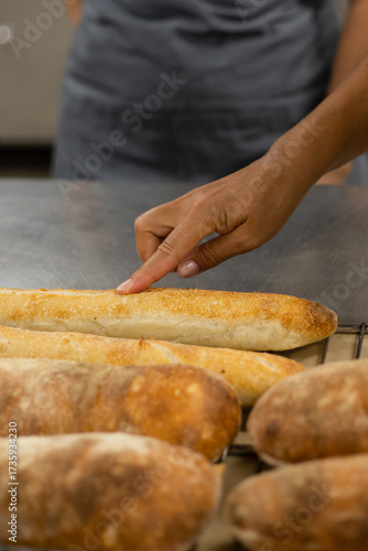 Baker checking fresh baguettes in a professional bakery kitchen
