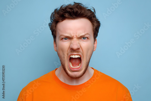 Angry Man Yelling in Orange Shirt Against Blue Background
