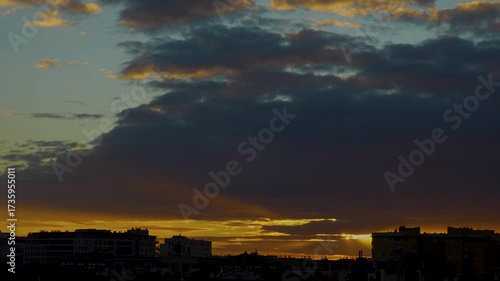 time lapse clouds over city at sunset