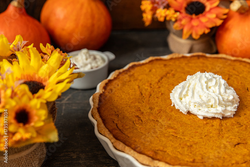 pumpkin pie oder Kuchen aus Kürbis angerichtet auf einem Tisch aus Holz und herbstlich oranger Dekoration