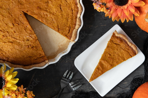 pumpkin pie oder Kuchen aus Kürbis angerichtet auf einem Tisch aus Holz und herbstlich oranger Dekoration
