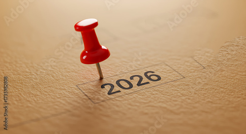 Red pushpin marking the year 2026 on a textured surface