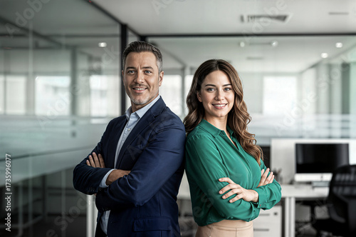 two happy executive managers mature business man and woman leaders concept successful partners professional team in their 50s standing arms crossed office at work looking at camera corporate portrait