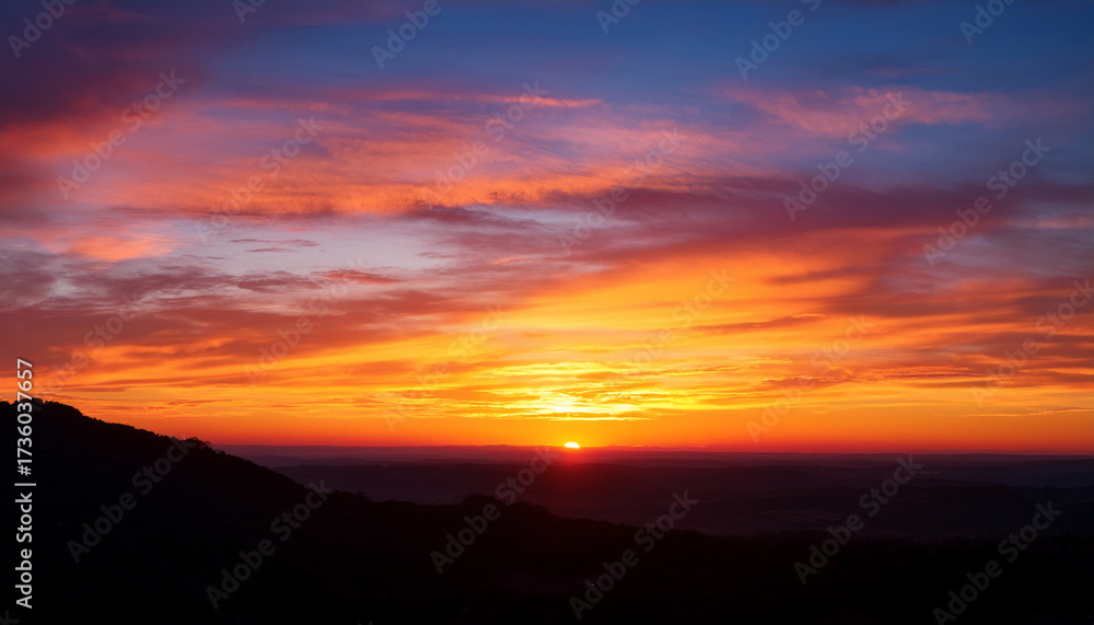 Obraz premium Vivid Sunset Over Horizon With Colorful Sky And Silhouetted Landscape