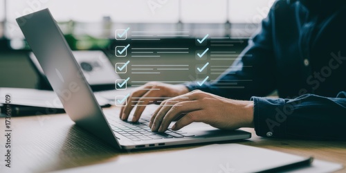 Businessman using laptop for online survey, filling out a digital form with a checklist and marking tasks as complete for quality assurance