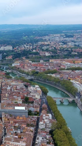 Breathtaking 4K vertical aerial video of Rome's Tiber River with bridges, lush trees, and historic cityscape. Stunning drone footage showcasing Italian capital waterway, perfect for mobile content.