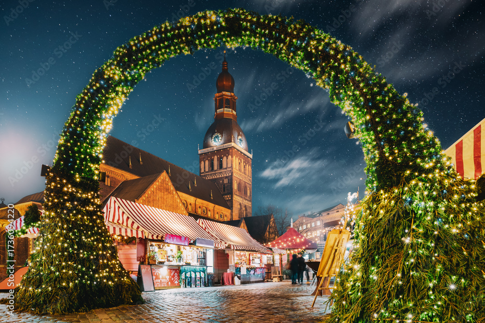 Fototapeta premium Riga, Latvia. Traditional Christmas Market On Dome Square With Cathedral. Famous Landmark In Winter Evening Night In Festive Illuminations Lighting