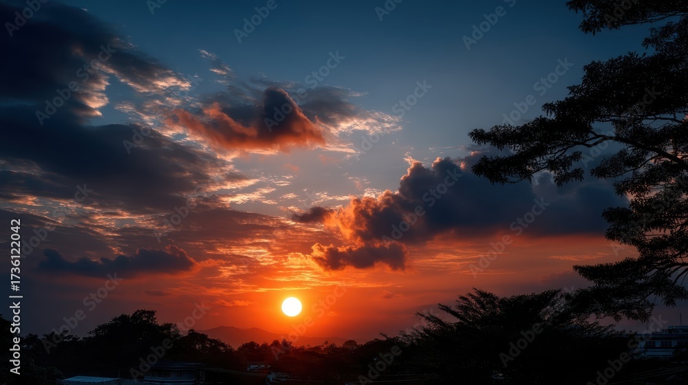 Obraz premium Majestic Sunset Over Mountains with Colorful Sky and Silhouetted Trees Capturing the Beauty of Nature in Evening Light