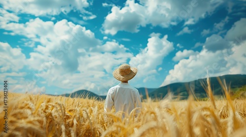 Rustic Farming Scene Featuring a Farmer in Straw Hat Under Big Cloudy Sky