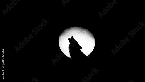 Silhouette of a howling wolf against the moon.