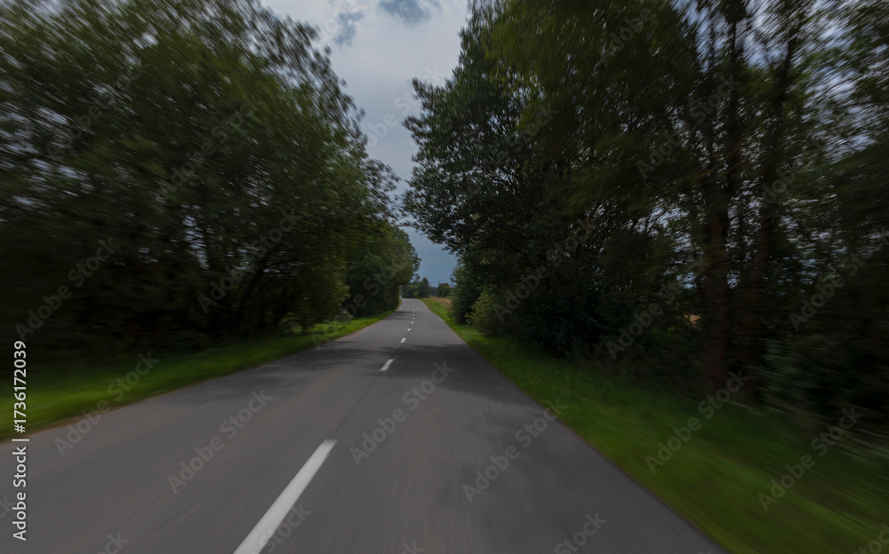 Obraz premium The effect of speed on the road and blur. View of the road on a summer day.