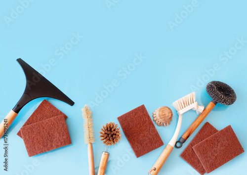 Top view cleaning supplies, bamboo brushes and natural sponges, zero waste household concept on a blue background