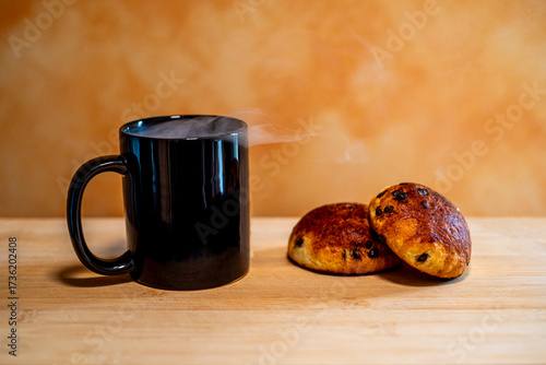 Idea di colazione italiana tu tavolo di legno chiaro con tazza nera e brioches