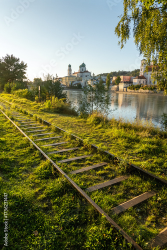Passau, Bavaria, Germany: evening light on the Inn river, the abandonned railway and the St Stephan cathedral (Dom)